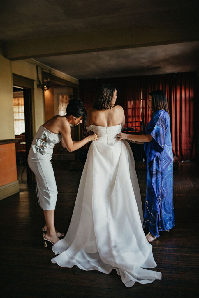 A bride gets dressed for her wedding at avant garden wedding