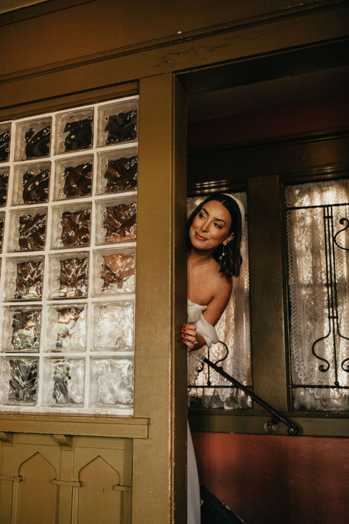 A bride peeks around the corner for a first look with her father at avant gardens houston