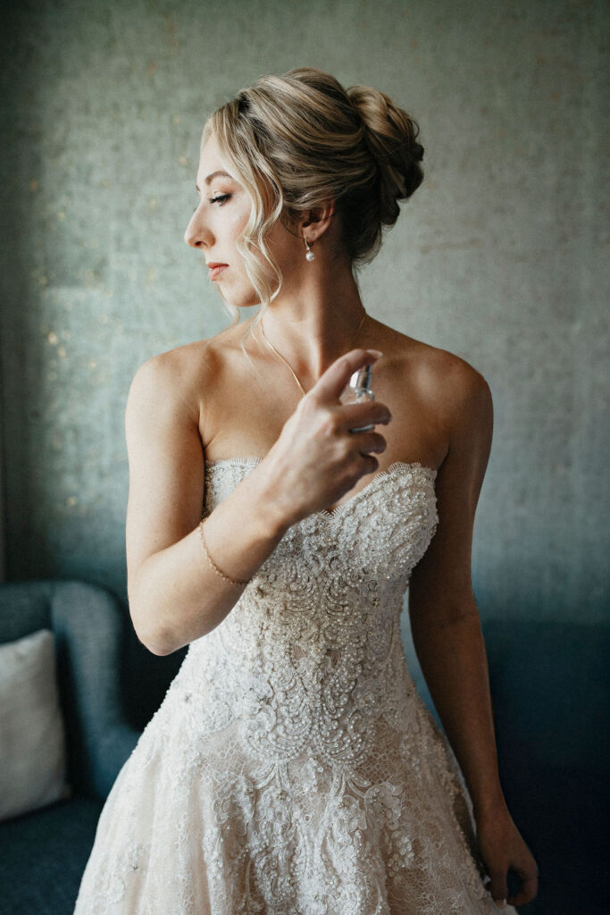 A bride spritzes perfume as she gets dressed for her elopement in Austin TX