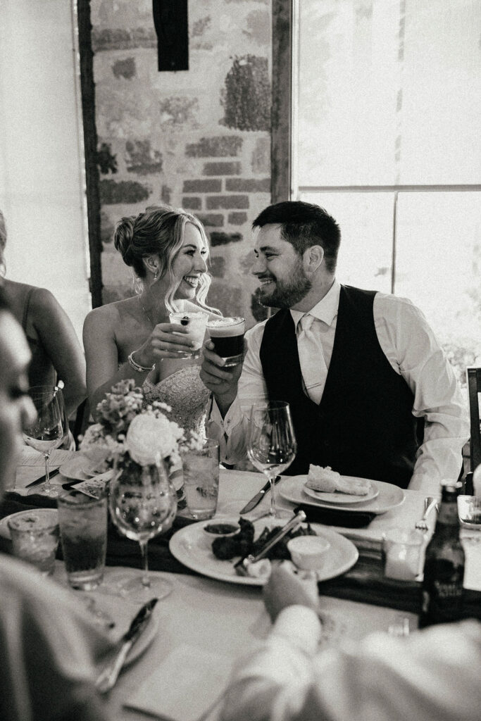 A b+w image taken by a texas elopement photographer showcases a bride & groom smiling at their reception