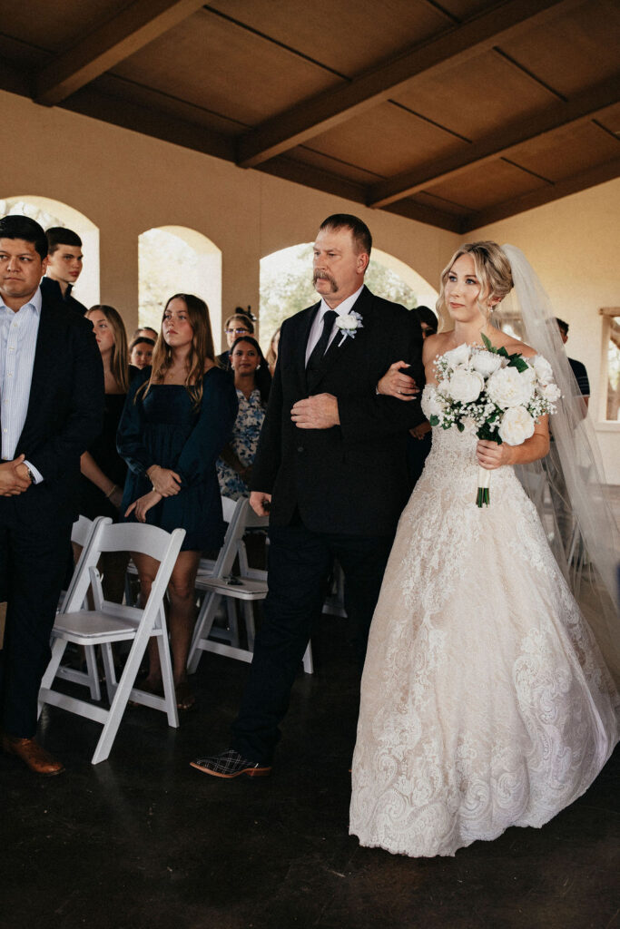 A bride is escorted down the aisle by her father at her elopement in texas