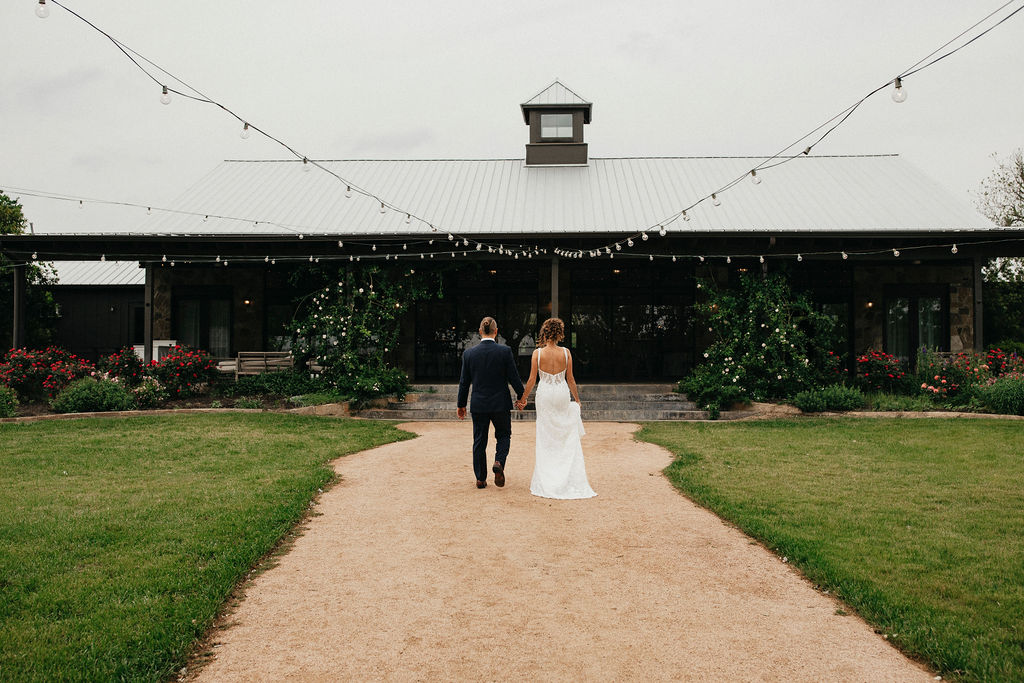 A bride and groom hold hands as they walk into their wedding reception austin tx