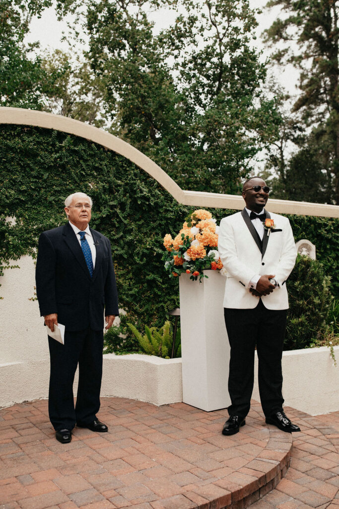 A groom waits at the altar during his wedding at the springs in cypress