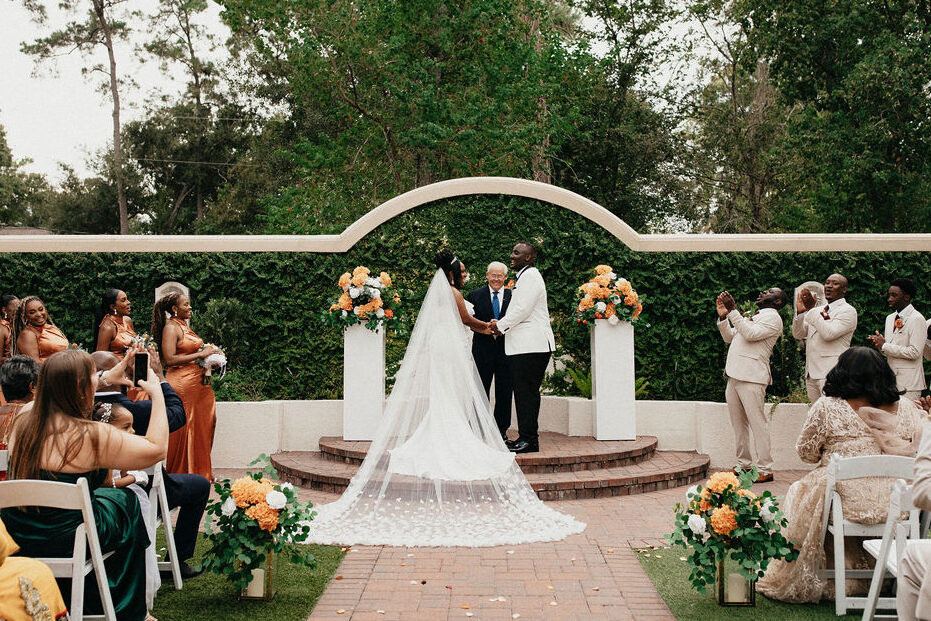 A wedding ceremony is photographed at the spring cypress