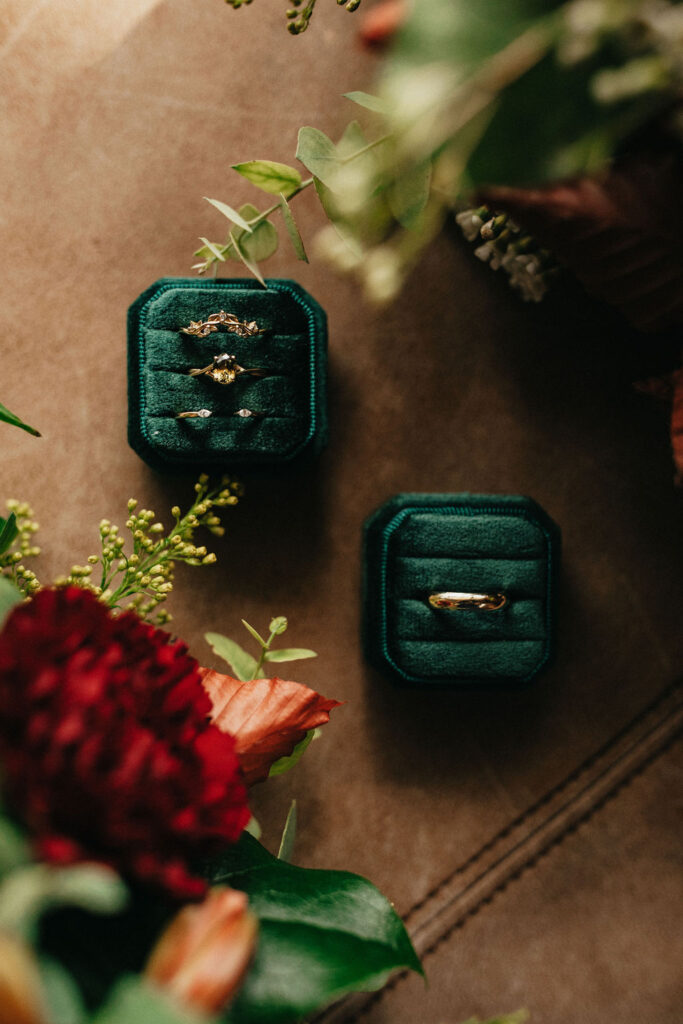 Wedding rings are photographed in green velvet boxes at a kindred oaks georgetown texas winter wedding 