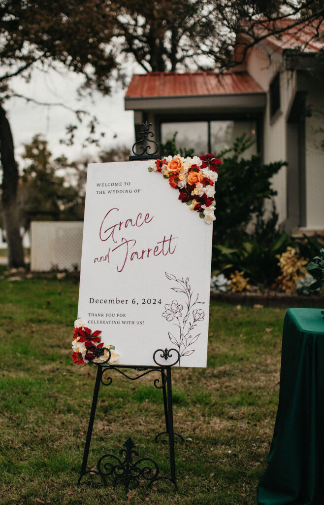 A welcome sign covered in winter florals is photographed at a georgetown wedding