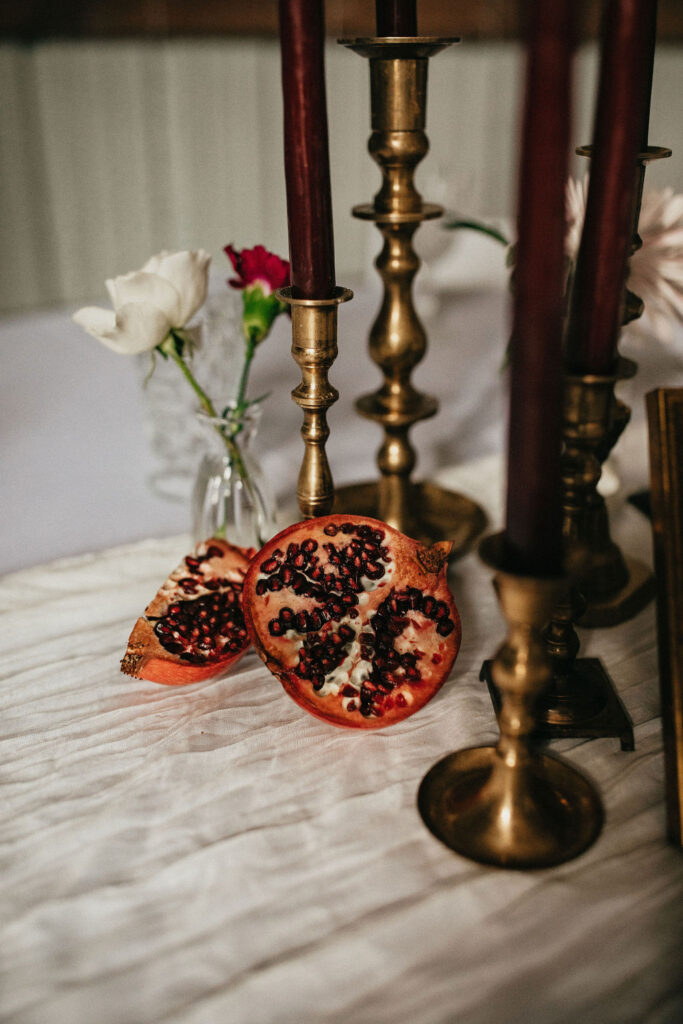 Brass candlesticks and pomegranate decor are pictured at a winter wedding in Houston 