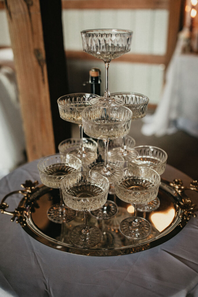 A  champagne tower is photographed at a Houston TX wedding reception