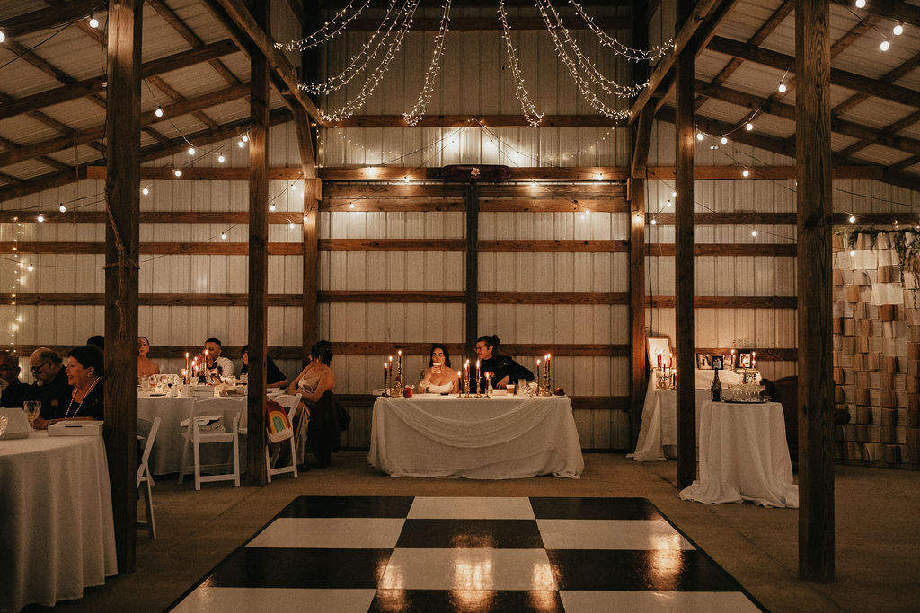A couple sips champagne at a candlelit reception at their Houston wedding 