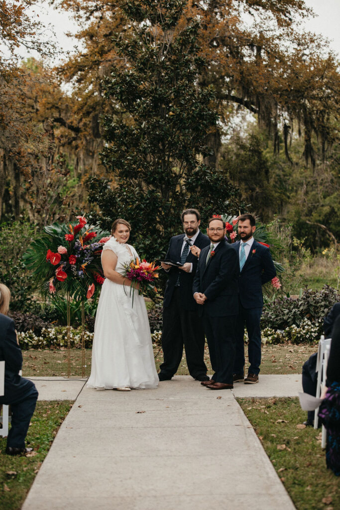 A bride and groom look out at their guests from the altar at their Houston Botanic Garden wedding 
