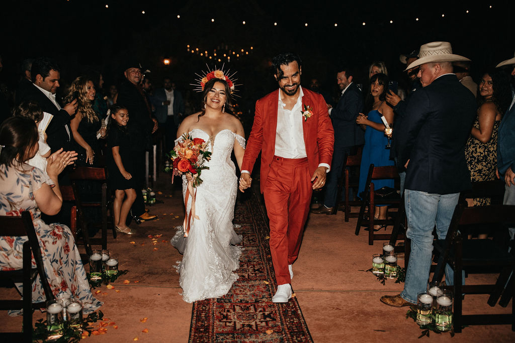 Newlyweds walk hand-in-hand down the aisle at Madera Estates, one of the many outdoor Houston wedding venues in the area