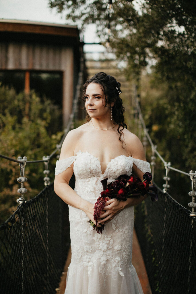 A Texas bride is photographed on a suspension bridge at cypress valley event center