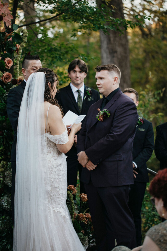 A bride reads personal vows to her groom at a Spicewood TX treehouse wedding 