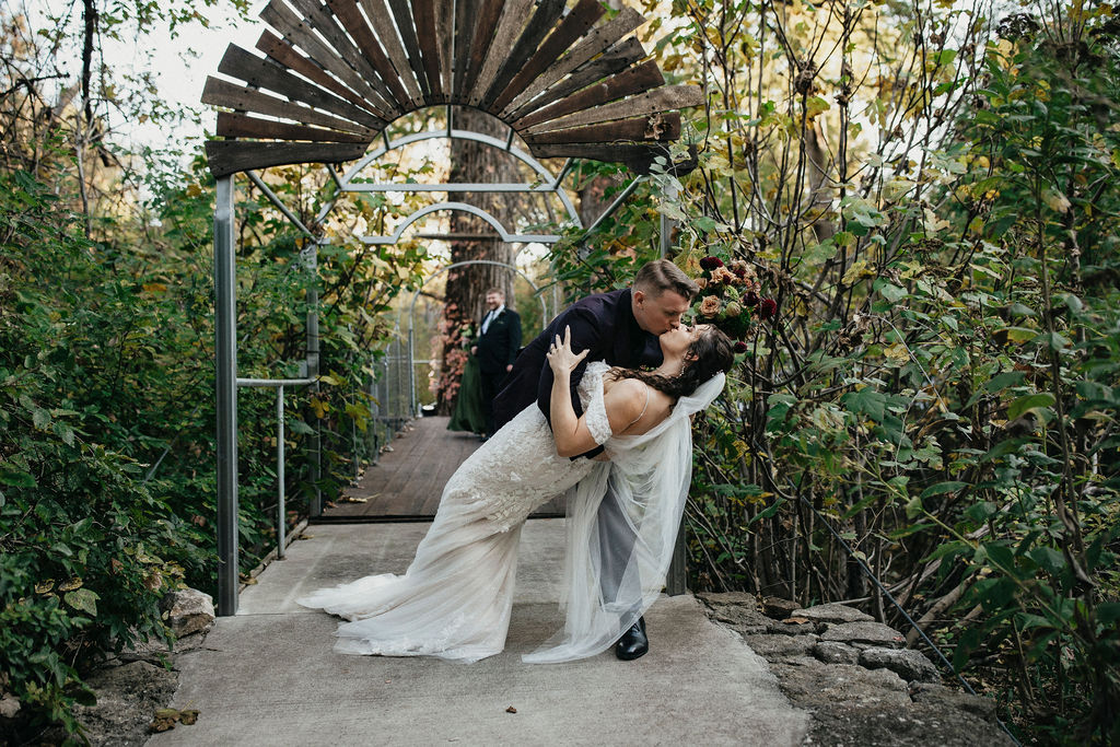 A kiss is captured at a wedding held at a Spicewood TX Treehouse wedding venue