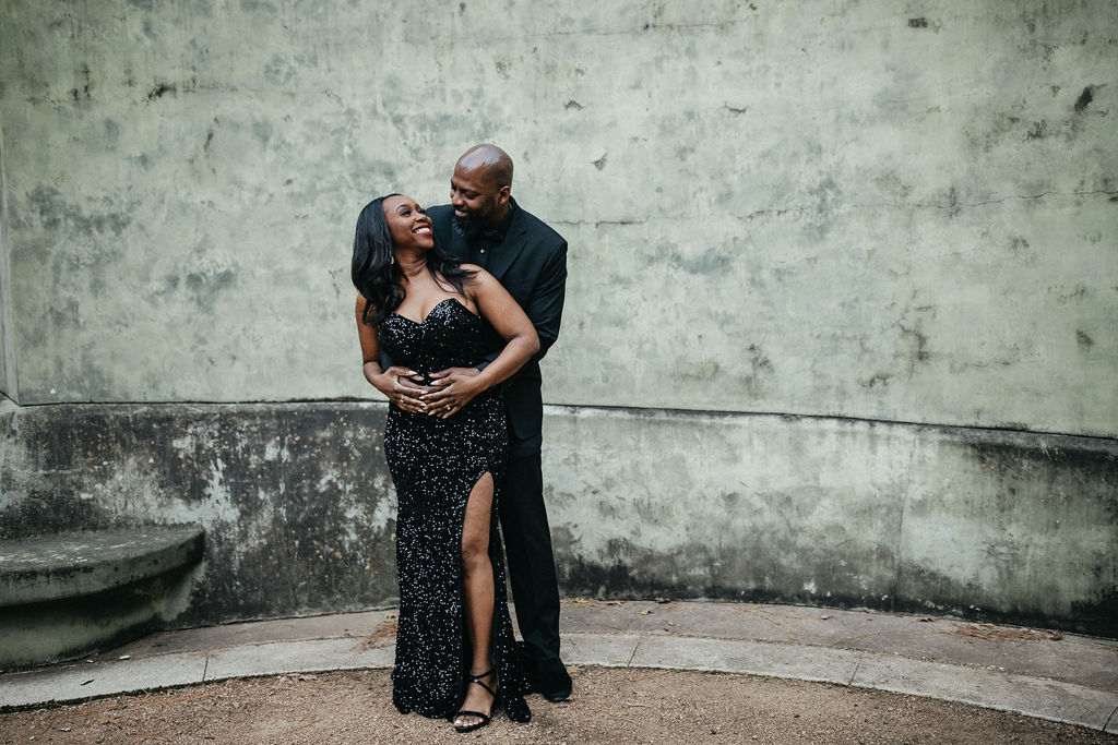 A newly-engaged couple smile during a Downtown Houston photoshoot with Houston engagement photographer 