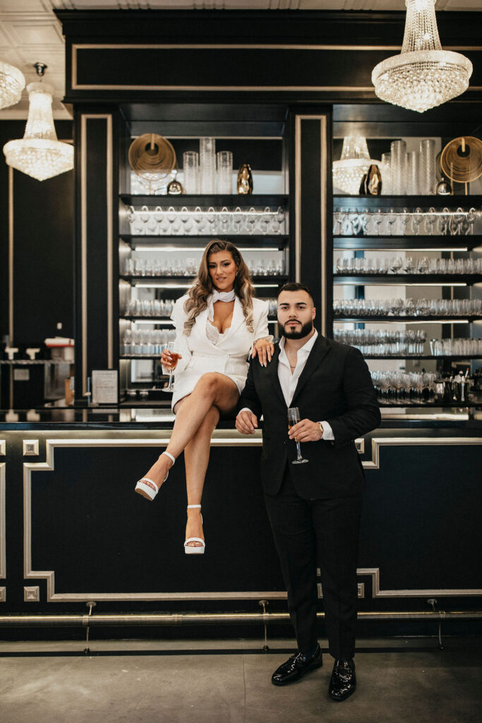 A couple is seated on the bar at Sandlewood Manor during a session with Houston engagement photographer, K Ruiz Photography 
