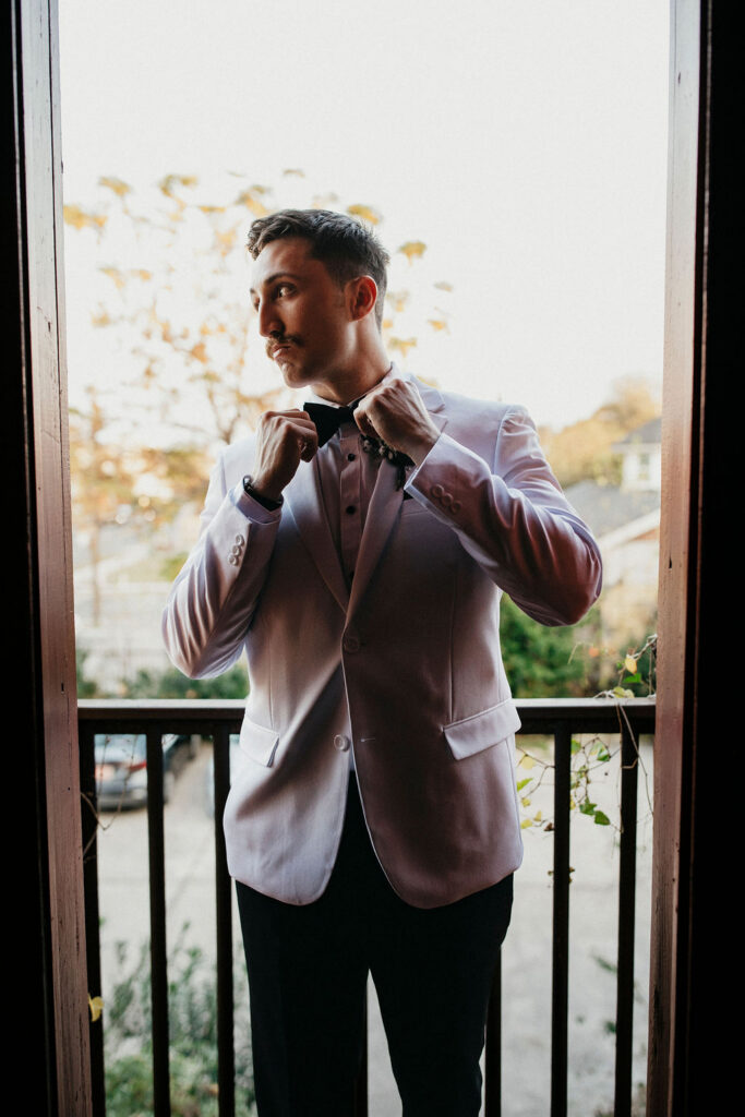A groom adjusts his bow tie before his Avant Garden Houston wedding. 