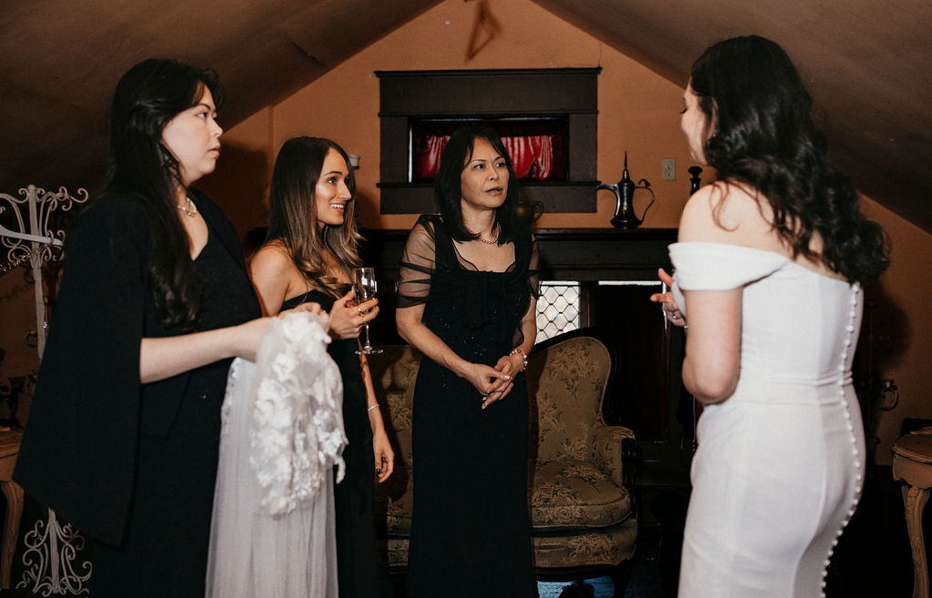 A bride chats excitedly with guests in a getting ready suite at her Avant Garden Houston wedding. 