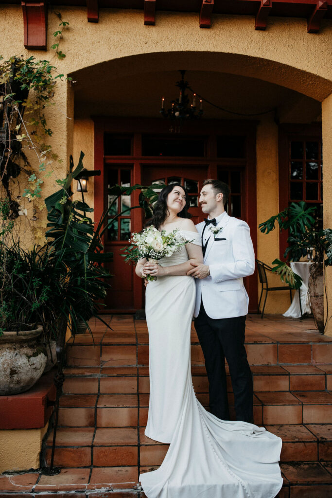Newlyweds pose for bridal portraits at the front of Avant Garden, a Houston wedding venue.