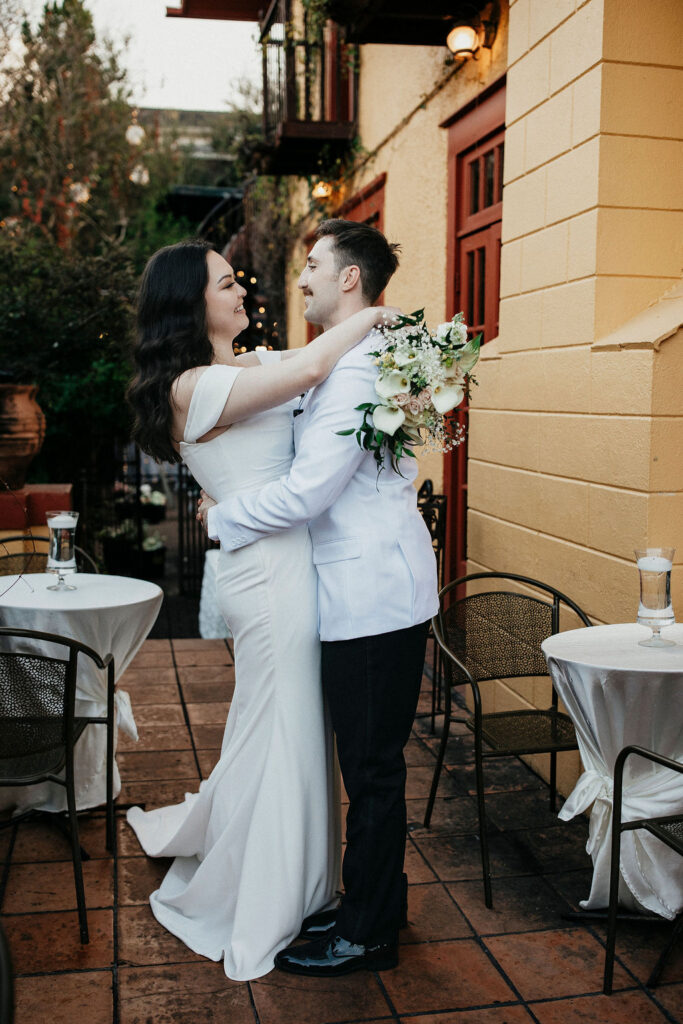 Newlyweds embrace for a bridal portrait before their night time wedding at Avant Garden Houston. 
