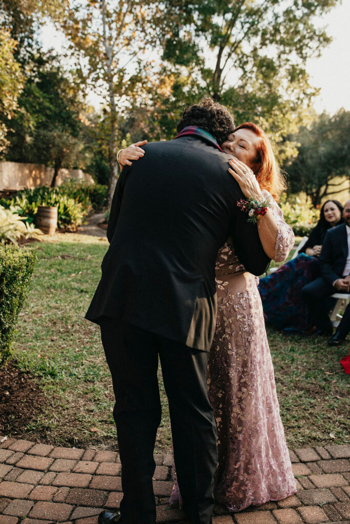 A groom hugs a guest at his Houston elopement. 