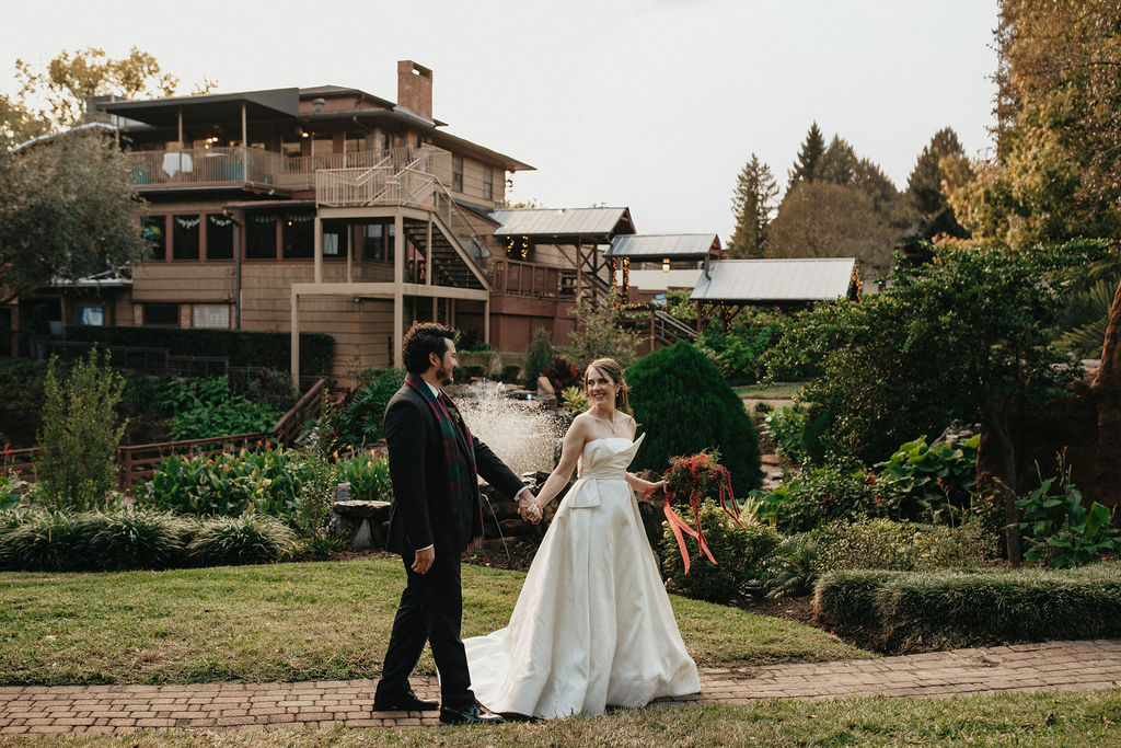 Texas newlyweds walk hand-in-hand along a brick path at Brenner's on the Bayou in a photo taken by a Houston elopement photographer. 