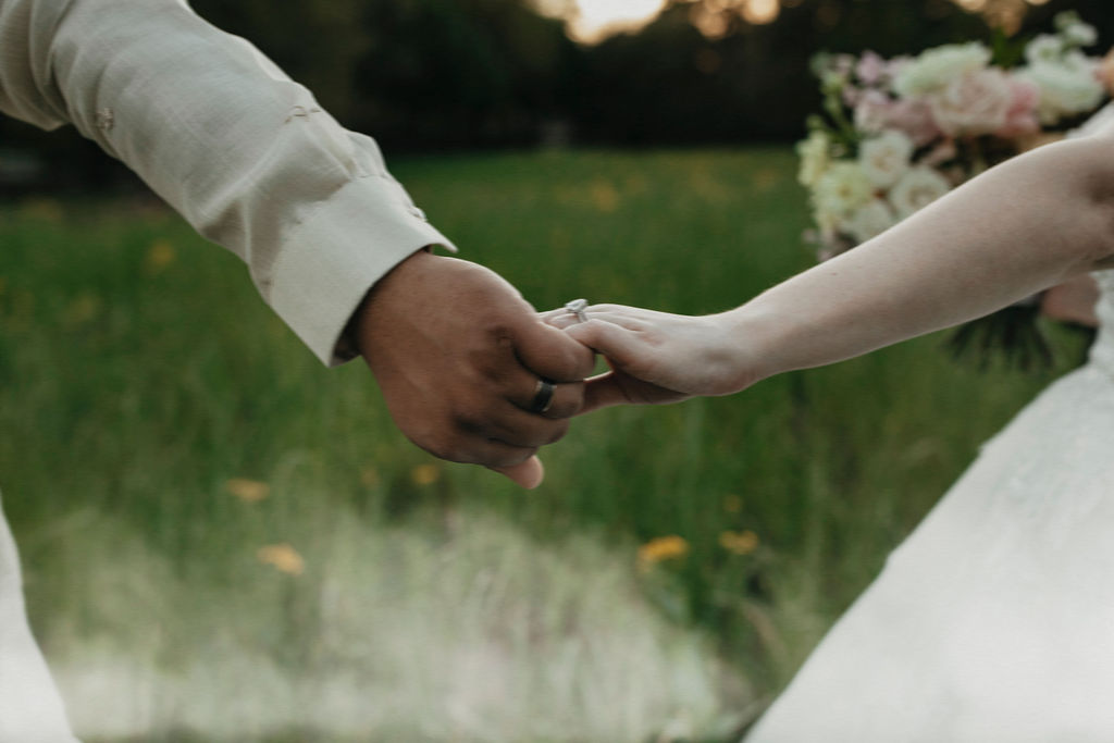 Newlyweds hold hands in a closeup taken at a Sandlewood Manor wedding in Texas. 