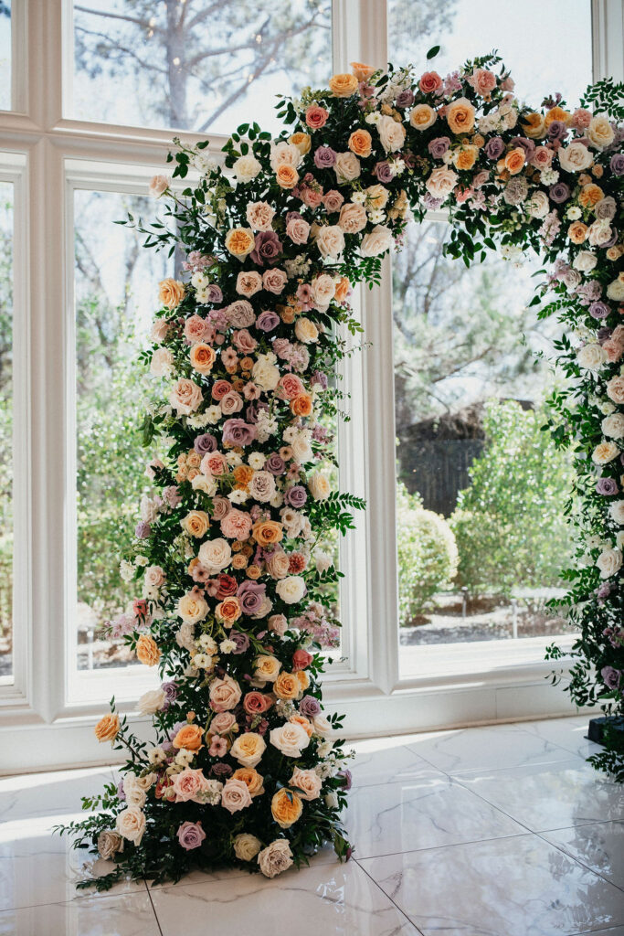 A spring floral wedding arch is photographed at a Sandlewood Manor wedding in Texas. 