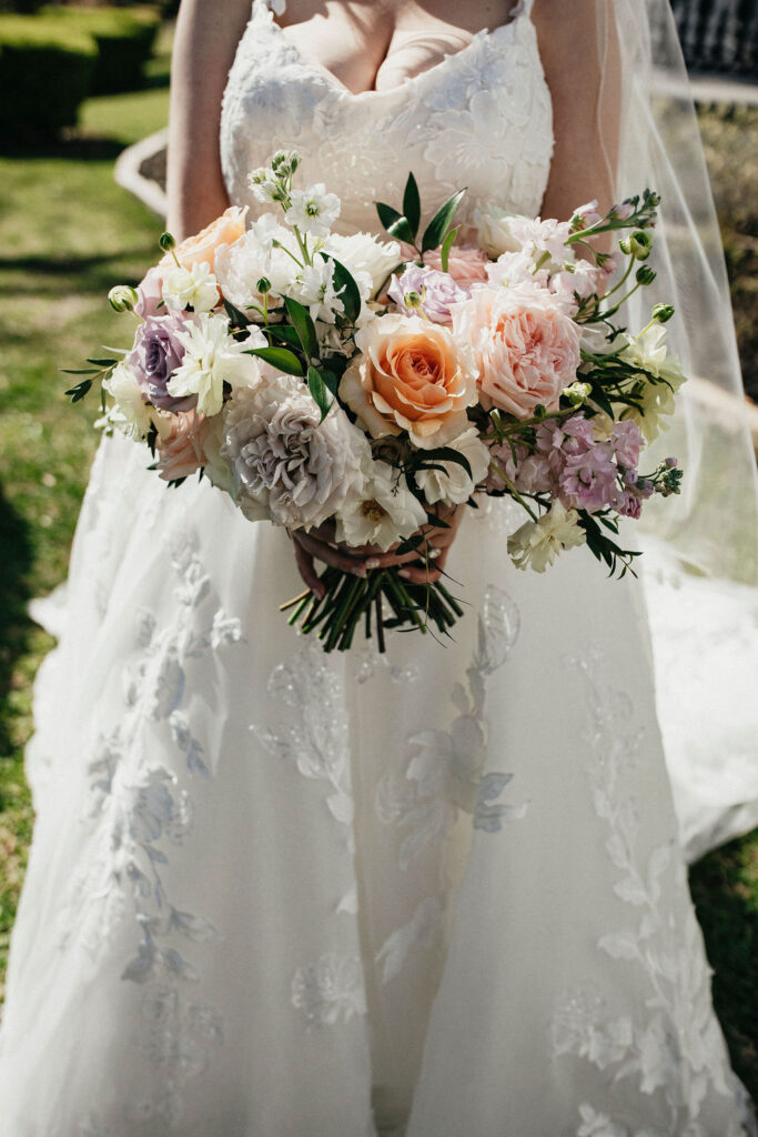 A spring bridal bouquet is photographed at a Texas wedding at Sandlewood Manor. 