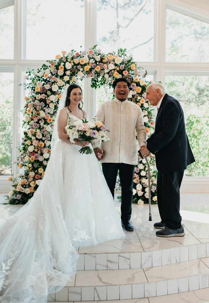Newlyweds laugh with a family member at their Sandlewood Manor wedding. 