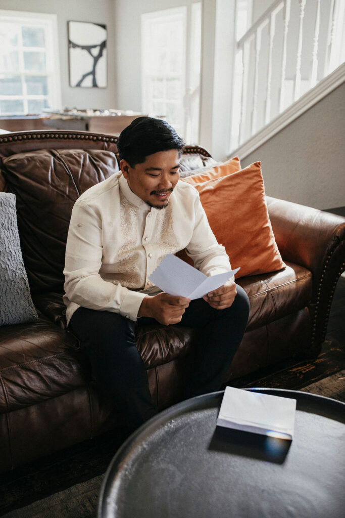 A groom reads a personal note from his bride before their Sandlewood Manor wedding. 