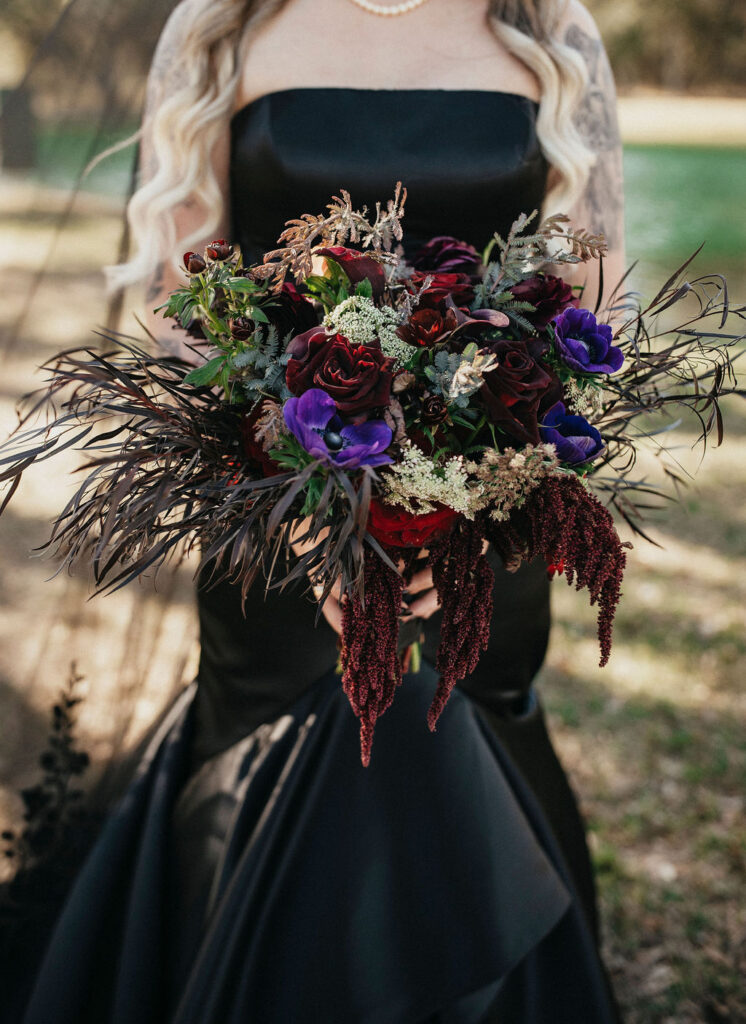 A gothic inspired wedding bouquet is photographed at a Texas ranch wedding.