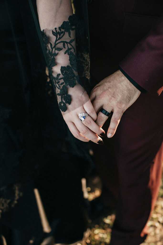 Newlyweds hold hands in a close-up photo of wedding rings taken at a Texas Ranch and Winery wedding.